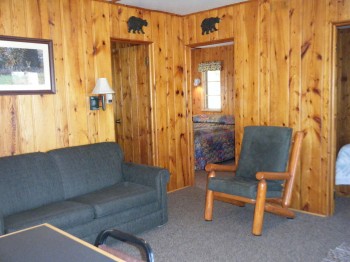 Cabin 3 living space inclues hide-a-bed couch and log accent furniture.  Cable TV with DVD/VHS player.